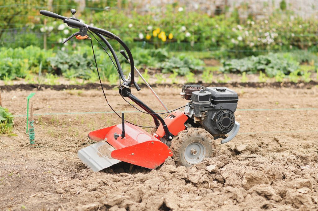 A plow plows the ground in the garden