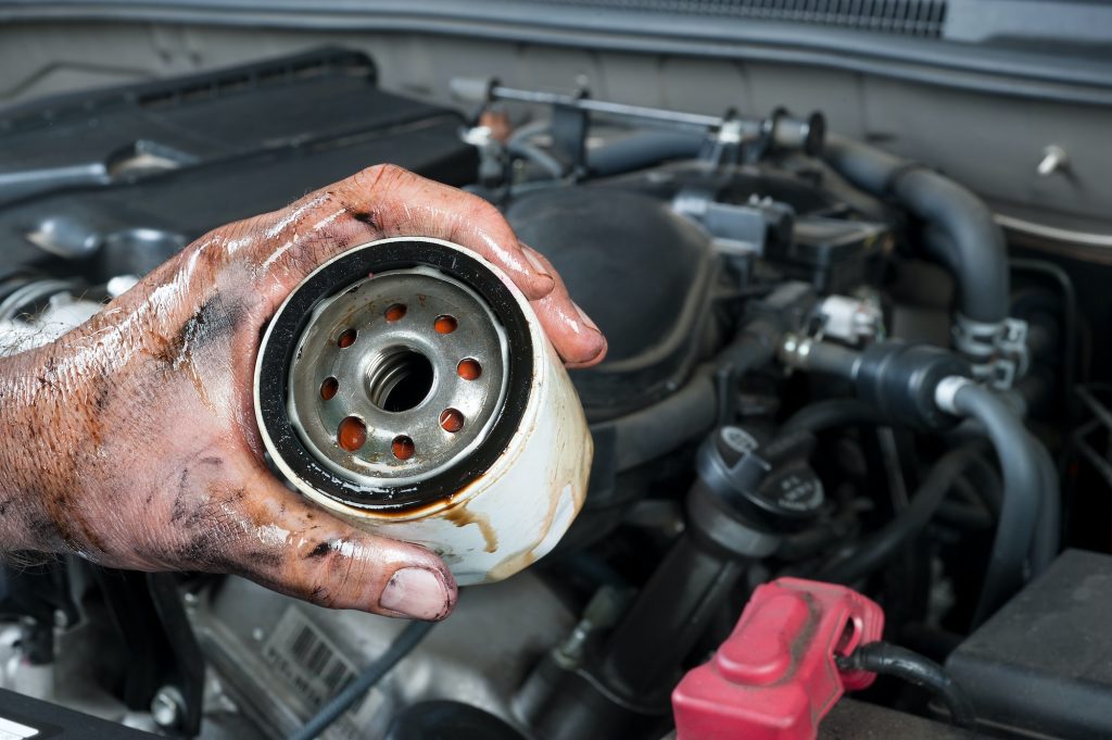 Auto mechanic holding oil filter